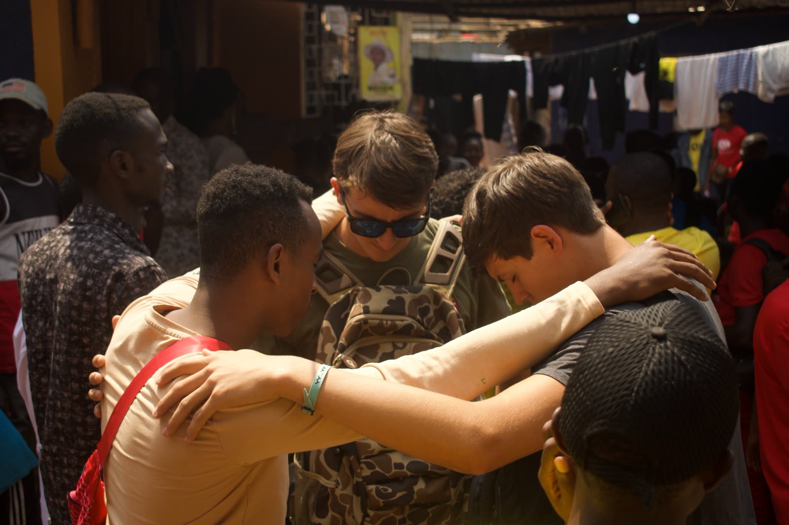 Young men praying together while serving in Uganda