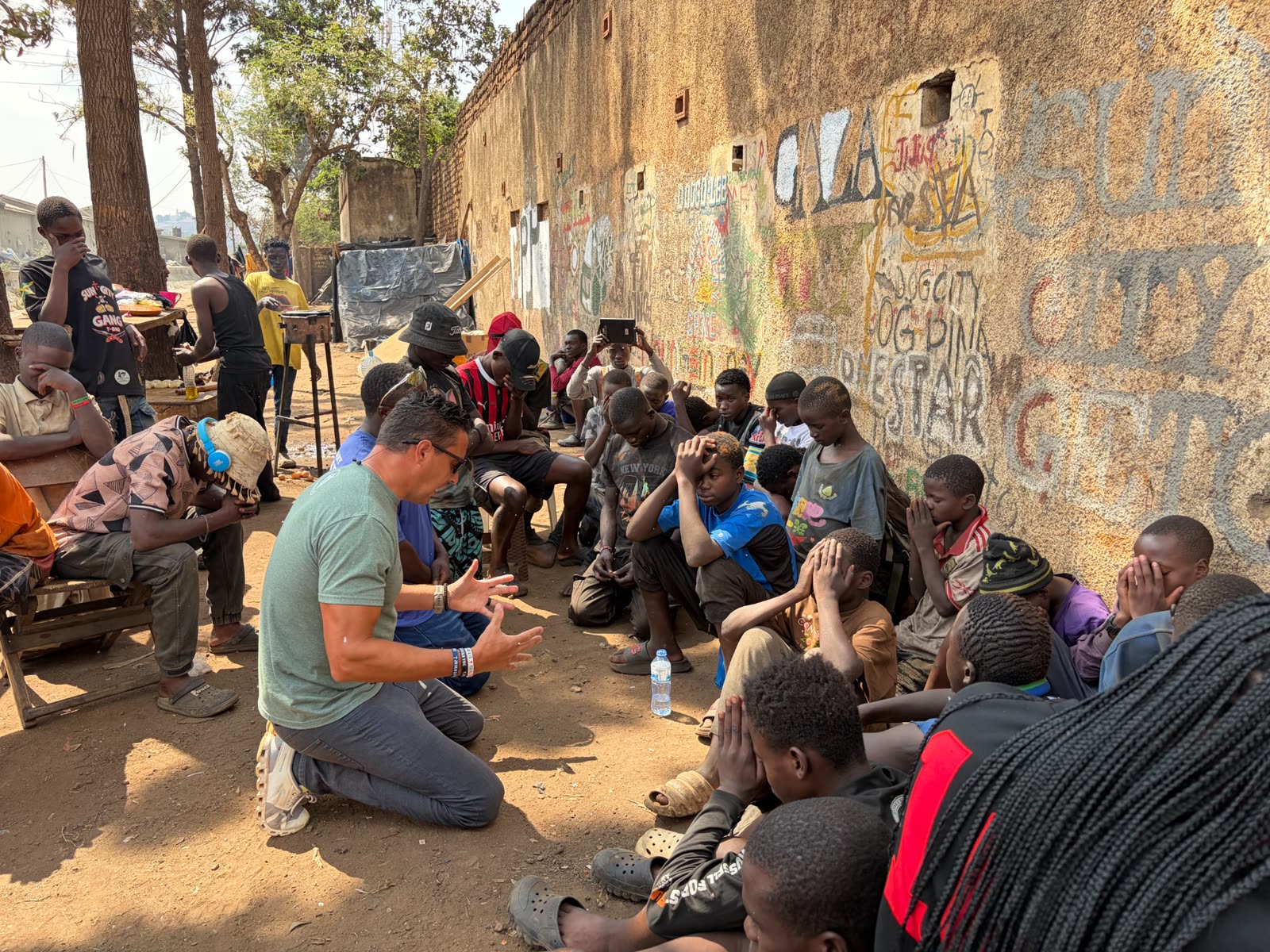 Chuckie praying with a group of young men in Uganda